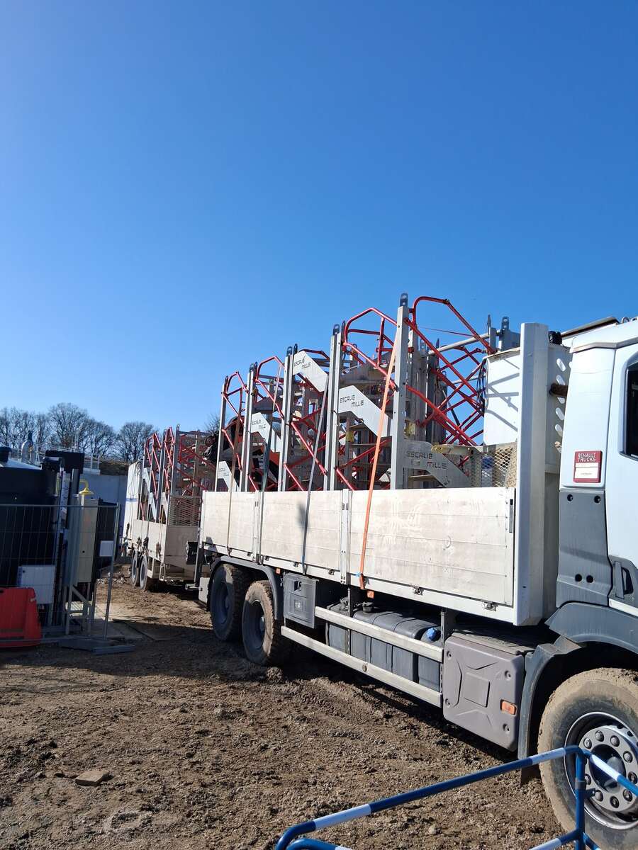 Camion plateau grue TWIN Transport Levage transportant un algeco de chantier